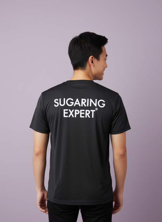Person wearing a black t-shirt with 'SUGARING EXPERT' text on the back against a purple background